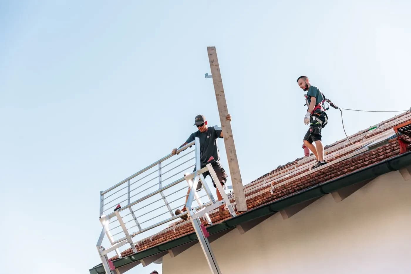 Handwerker sichern sich auf dem Dach ab