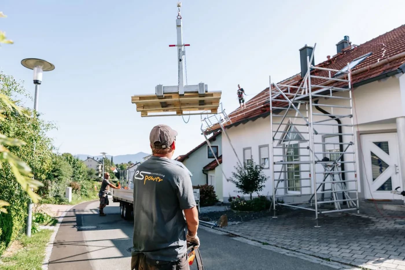 Monteur führt ein Solarmodul am Kran