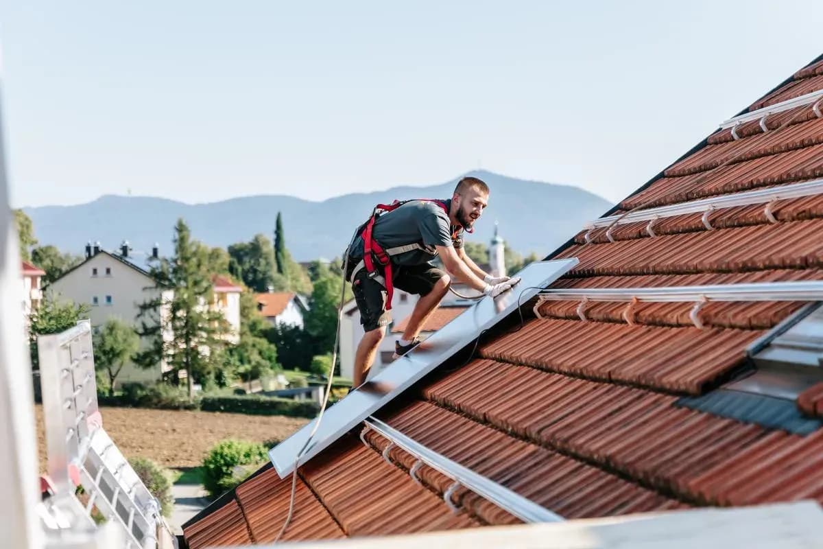 Monteur setzt ein Solarmodul auf dem Dach ein